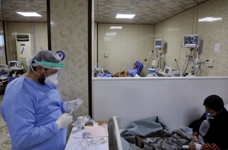 &copy; Reuters. FILE PHOTO: A medical staff assists patients suffering from the coronavirus disease inside the COVID-19 ward of a hospital in the opposition-held Idlib, Syria September 26, 2021. REUTERS/Mahmoud Hassano