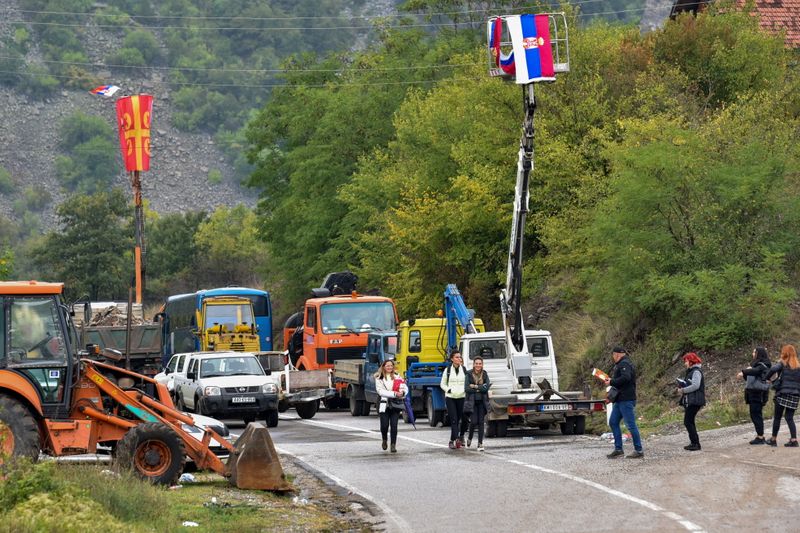 &copy; Reuters. FOTO DE ARCHIVO: Ciudadanos kosovares de etnia serbia atraviesan una zona de barricadas cerca de la frontera serbo-kosovar en Jarinje, Kosovo, el 28 de septiembre de 2021. REUTERS/Laura Hasani