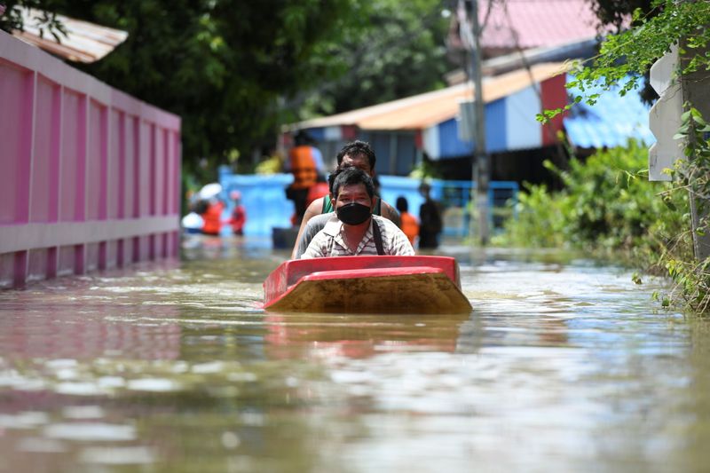 &copy; Reuters. People ride a boat through a flooded street in Ban Sai village, Ban Mi district in Lopburi province, Thailand, September 30, 2021. REUTERS/Panumas Sanguanwong NO RESALES. NO ARCHIVES.