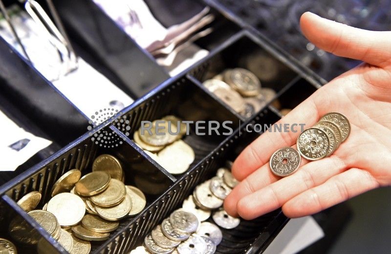 &copy; Reuters. Garçonete posa com algumas moedas de coroas dinamarquesas no caixa de um bar em Copenhague, 22 de janeiro de 2015. REUTERS/Fabian Bimmer