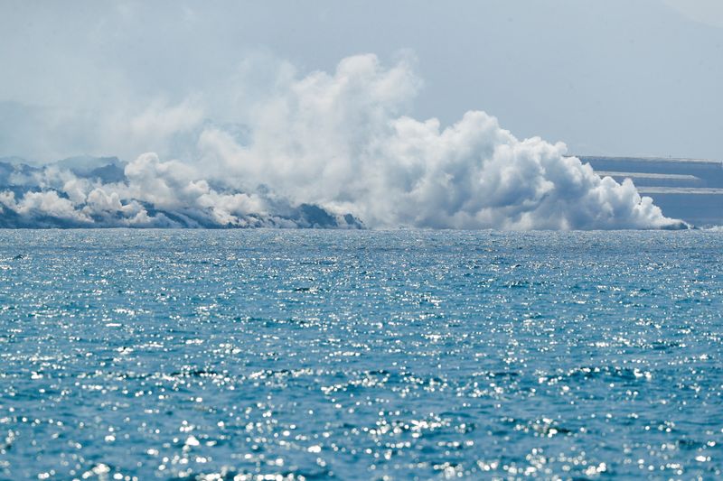 &copy; Reuters. Columnas de humo se elevan desde las aguas del mar al entrar en contacto con la lava surgida del volcán Cumbre Vieja, vistas desde el puerto de Tazacorte, en la isla de La Palma, Islas Canarias, España, el 30 de septiembre de 2021. REUTERS/Borja Suárez