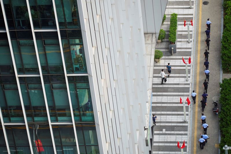 &copy; Reuters. Police officers and security personnel walk outside the headquarters of China Evergrande Group in Shenzhen, Guangdong province, China, September 30, 2021. REUTERS/Aly Song