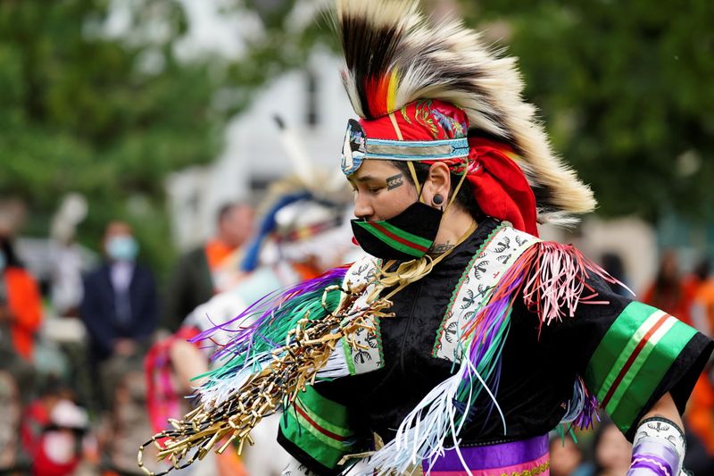 © Reuters. Nanook Gordon, from Inuvik, dances while wearing grass dance regalia during Canada's first National Day for Truth and Reconciliation, honouring the lost children and survivors of Indigenous residential schools, their families and communities, in Toronto, Ontario, Canada September 30, 2021. REUTERS/Carlos Osorio 