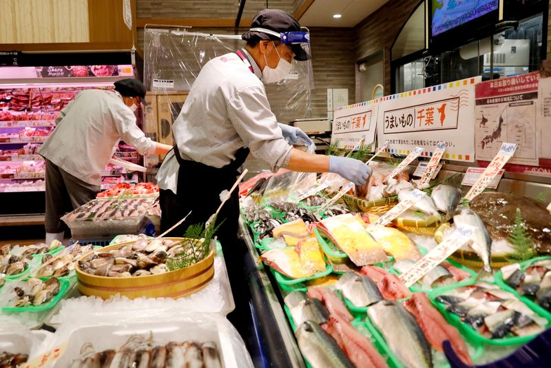 &copy; Reuters. FILE PHOTO: A staff wearing a face shield sells fish at Japan's supermarket group Aeon's shopping mall as the mall reopens amid the coronavirus disease (COVID-19) outbreak in Chiba, Japan May 28, 2020. REUTERS/Kim Kyung-Hoon/File Photo