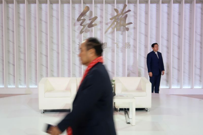 &copy; Reuters. A man walks past a Hongqi, or Red Flag, sign during an event of the Chinese car marque owned by FAW Group held at the Great Hall of the People in Beijing, China January 8, 2020. Picture taken January 8, 2020. REUTERS/Yilei Sun