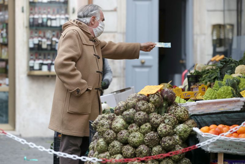 &copy; Reuters. FILE PHOTO: A man shops groceries at an open-air market as the government is due to announce stricter coronavirus disease (COVID-19) restrictions, in Rome, Italy, March 12, 2021. REUTERS/Yara Nardi
