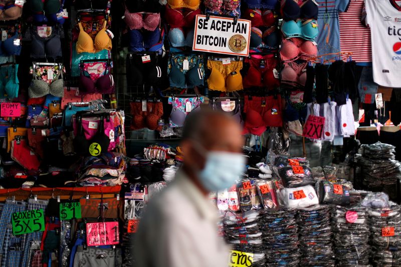 &copy; Reuters. FILE PHOTO: A man walks by a sign that reads, "Bitcoin accepted here", on a street stall where the cryptocurrency is accepted as a payment method in San Salvador, El Salvador September 24, 2021. REUTERS/Jose Cabezas/File Photo