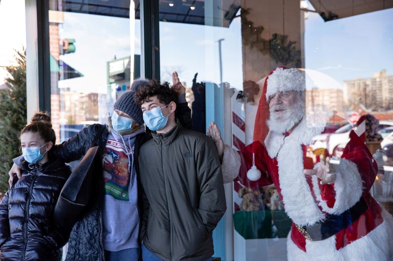 &copy; Reuters. FILE PHOTO: Dana Friedman, a trial lawyer who has spent 6 months of each year growing out his beard for his annual appearance as Santa Claus since 2001, poses for a portrait with a family through a window at the Bay Terrace Shopping Center in New York Cit