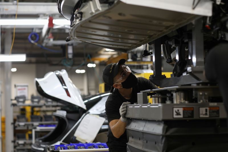 &copy; Reuters. Trabalhador busca casar a estrutura da carroceria com a bateria e as subestruturas dianteira e traseira enquanto monta veículos elétricos na fábrica da Lucid Motors em Casa Grande, Arizona, EUA, 28 de setembro de 2021. REUTERS/Caitlin O'Hara