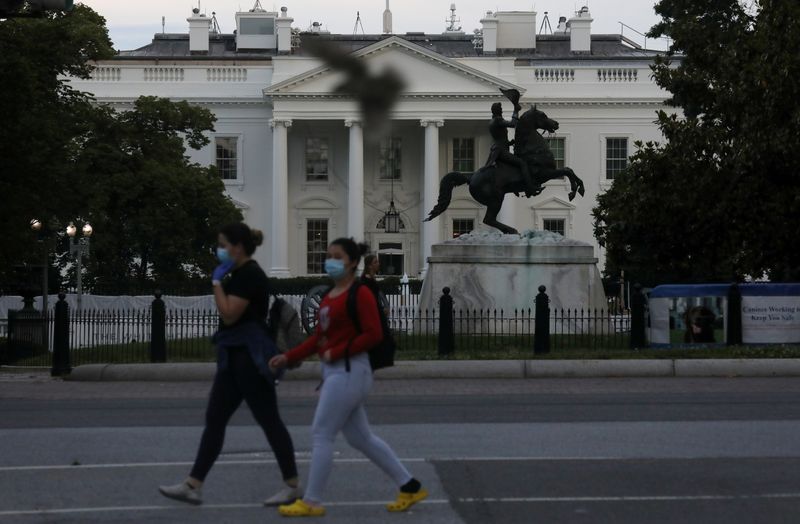 &copy; Reuters. FILE PHOTO: Pedestrians walk in front of the White House as the coronavirus disease (COVID-19) outbreak continues in Washington, U.S., May 27, 2020. REUTERS/Leah Millis