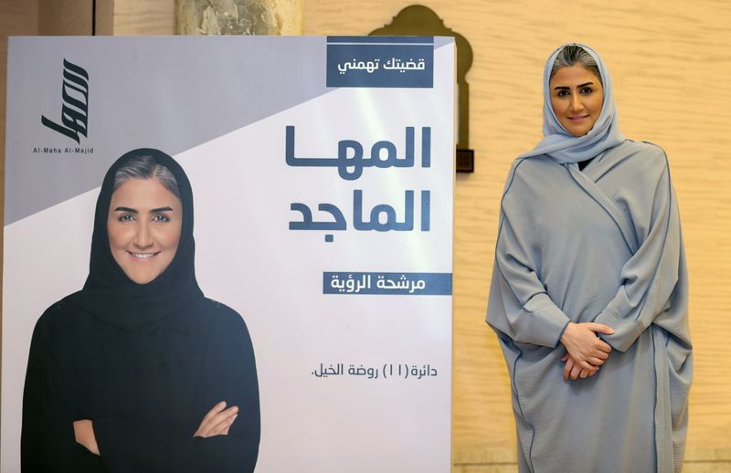 &copy; Reuters. FILE PHOTO: Al-Maha Al-Majid, a candidate in Qatar's Shura Council election, poses for a photo next to an election poster in Doha, Qatar September 30, 2021. REUTERS/Ibraheem Al Omari