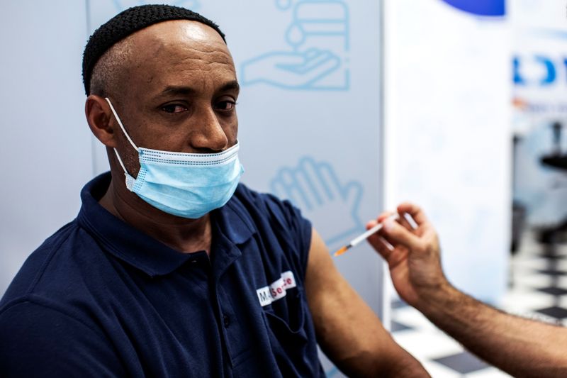 &copy; Reuters. FILE PHOTO: Israeli Izhak Mesfin, 44 years old, receives a third shot of coronavirus disease (COVID-19) vaccine as country launches booster shots for over 30-year-olds, in Rishon Lezion, Israel August 24, 2021. REUTERS/ Nir Elias