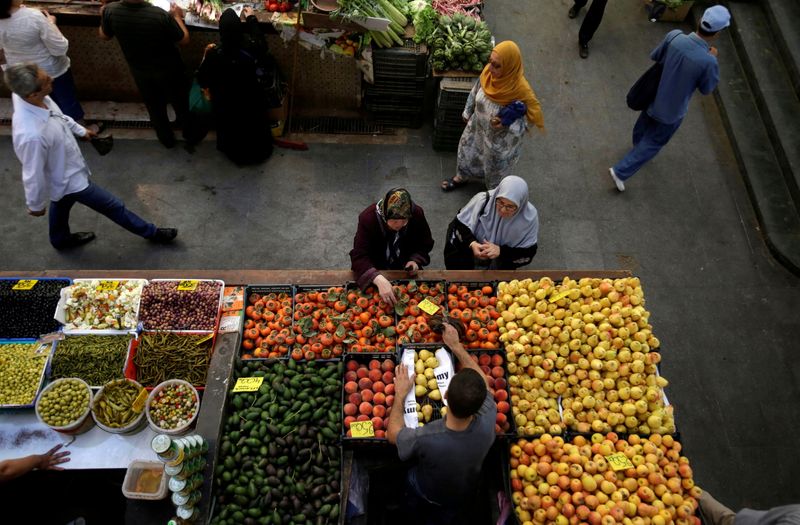 &copy; Reuters. اشخاص يشترون خضروات وفاكهة في سوق بمدينة الجزائر بصورة من أرشيف رويترز.
