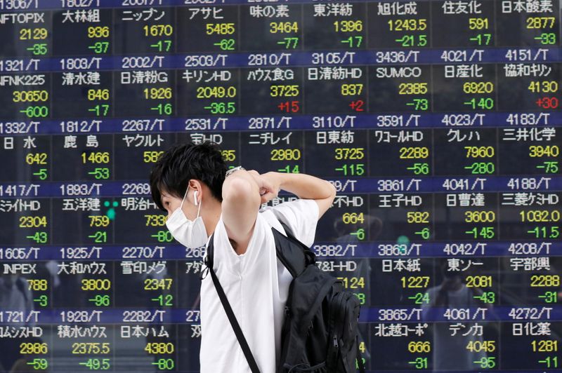 &copy; Reuters. Homem passa por painel eletrônico com informações acionárias em uma corretora em Tóquio
01/09/2021. 
REUTERS/Kim Kyung-Hoon