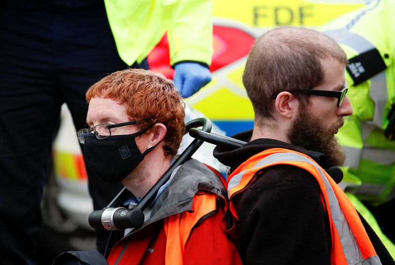 &copy; Reuters. محتجان من جماعة إنسوليت بريتين (اعزلوا بريطانيا) البريطانية المدافعة عن البيئة يشاركان في احتجاج لاغلاق طريق رئيسية في العاصمة لندن في أول 