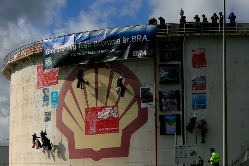 © Reuters. Environmental activist groups including Greenpeace are seen climbing a Shell oil tank to protest against 