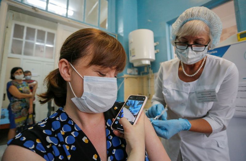 &copy; Reuters. A woman films on a phone as she is injected with Sputnik Light vaccine against the coronavirus disease (COVID-19)  at a local hospital in the rebel-controlled city of Donetsk, Ukraine August 2, 2021. REUTERS/Alexander Ermochenko