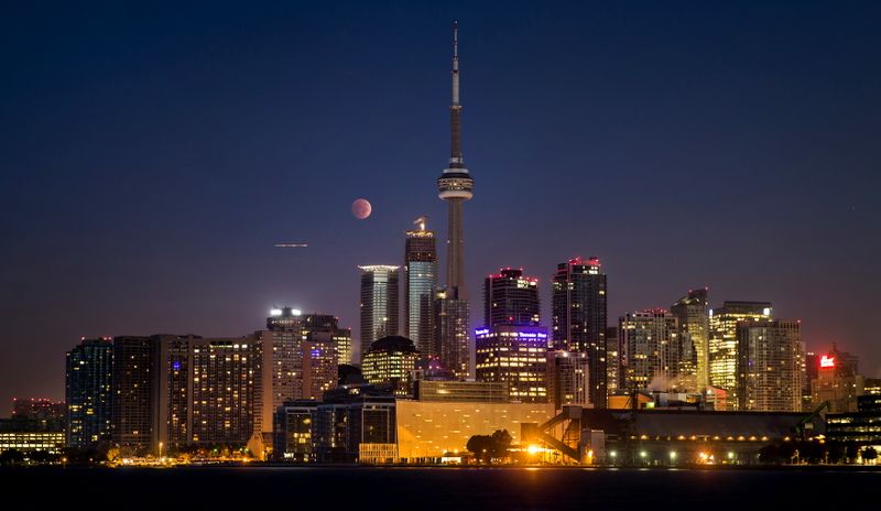 &copy; Reuters. FILE PHOTO: The moon turns orange during a total lunar eclipse behind the CN Tower and the skyline during moonset in Toronto, October 8, 2014. REUTERS/Mark Blinch/File Photo