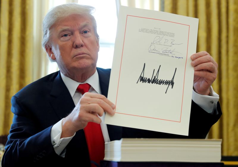 © Reuters. FILE PHOTO: U.S. President Donald Trump displays his signature after signing the $1.5 trillion tax overhaul plan in the Oval Office of the White House in Washington, U.S., December 22, 2017. REUTERS/Jonathan Ernst