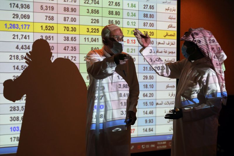 &copy; Reuters. متعاملون في بورصة السعودية في الرياض يراجعون أسعار الأسهم على شاشة. صورة من أرشيف رويترز.
