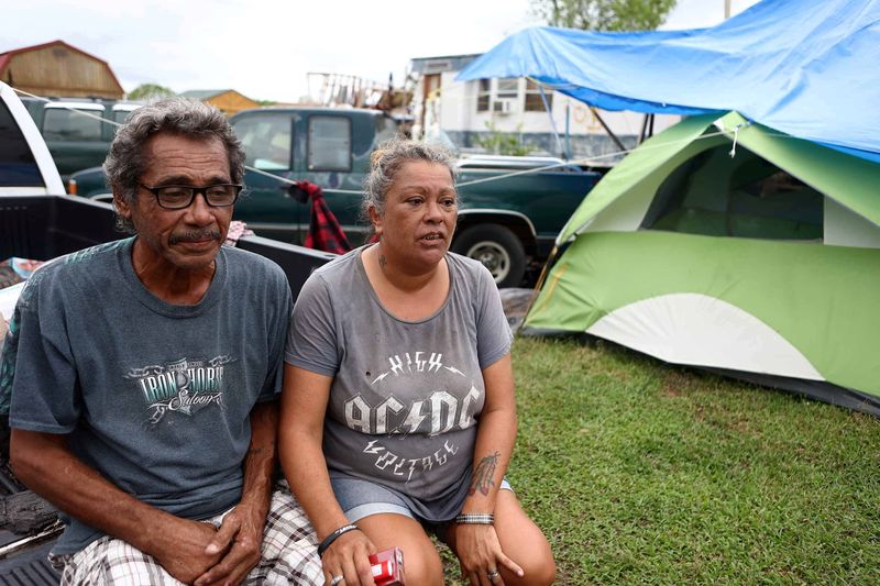 © Reuters. Bruce Westley sits with his wife Christina near the tent that they both currently live in while their trailer in the background has been destroyed a result of Hurricane Ida in Houma, Louisiana, U.S., October 2, 2021. REUTERS/Peter G. Forest/Forest Photography