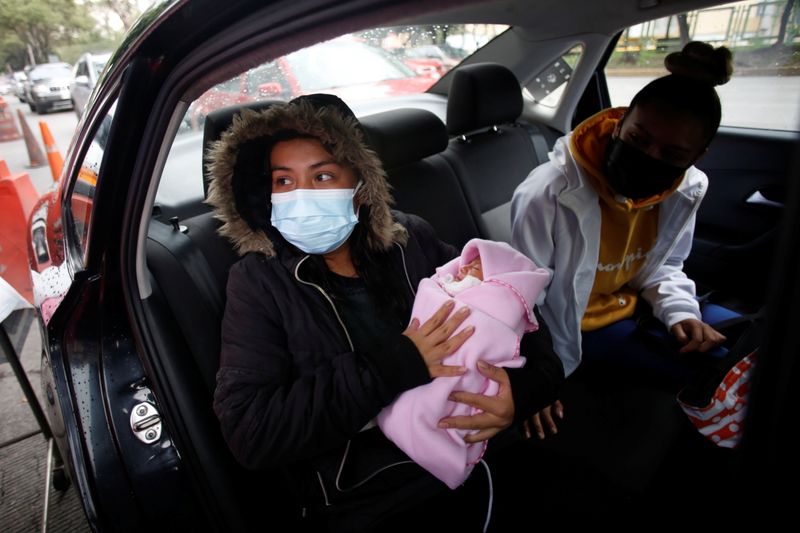 © Reuters. امرأة شُفيت من فيروس كورونا تحمل طفلها عقب مغادرتها مستشفى في مكسيكو سيتي في أول سبتمبر أيلول 2021. تصوير: رويترز.