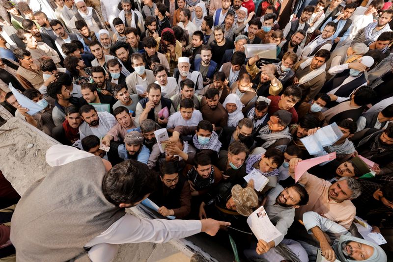 &copy; Reuters. Afghans gather outside the passport office after Taliban officials announced they will start issuing passports to its citizens again, following months of delays that hampered attempts by those trying to flee the country after the Taliban seized control, i