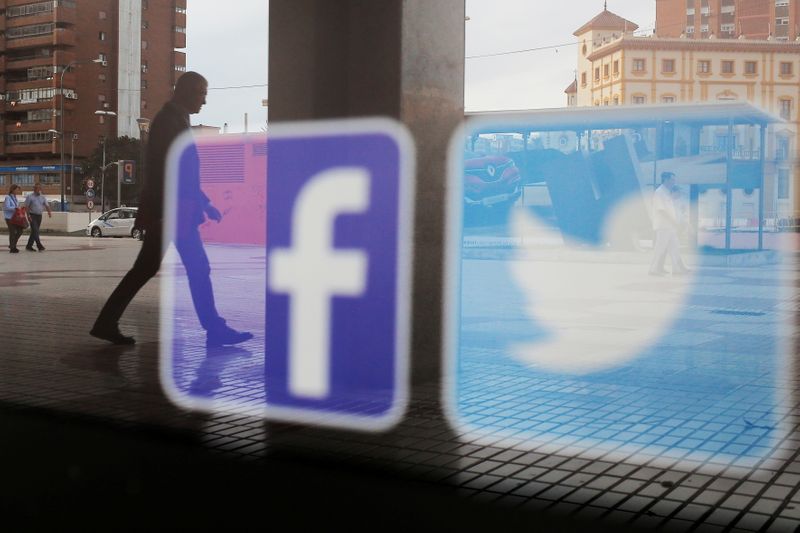 &copy; Reuters. FILE PHOTO: Facebook and Twitter logos are seen on a shop window in Malaga, Spain, June 4, 2018. REUTERS/Jon Nazca/File Photo