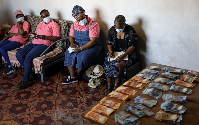 &copy; Reuters. Bank notes are placed on the table after contributions from members of the Save Act, an informal savings club known as stokvels, during one of their gatherings in Vanderbilpark, in the south of Johannesburg, South Africa, September 11, 2021. REUTERS/Siphi