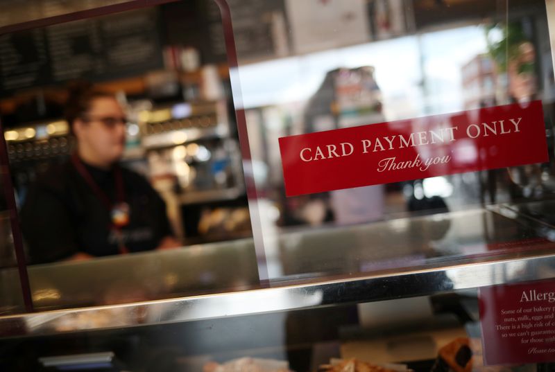 &copy; Reuters. FILE PHOTO: An employee is seen working behind a protective screen and a sign reading "Card payment only" in a Pret a Manger store that has reopened for delivery and takeaway in Wimbledon, following the outbreak of the coronavirus disease (COVID-19), Lond