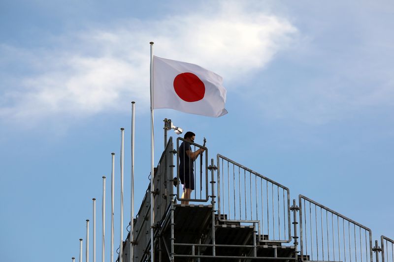 &copy; Reuters. Un uomo sotto la bandiera giapponese su uno stand vuoto per spettatori all'Aomi Urban Sports Park ai Giochi Olimpici di Tokyo 2020, a Tokyo, Giappone, 5 agosto 2021. REUTERS/Kevin Coombs
