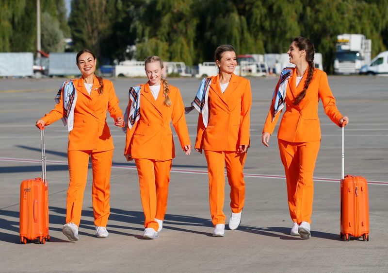 &copy; Reuters. Flight attendants of SkyUp Airlines walk along a tarmac during the presentation of a new uniform at the Boryspil International Airport outside Kyiv, Ukraine September 30, 2021. The Ukrainian low-cost airline presented their innovative uniform, including l