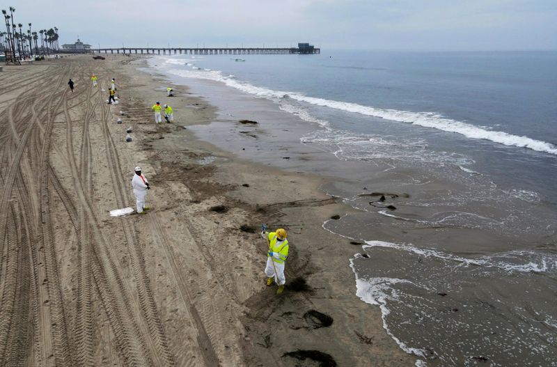 &copy; Reuters. FILE PHOTO: Workers rake up crude oil, after more than 3,000 barrels (126,000 gallons) of crude oil leaked from a ruptured pipeline into the Pacific Ocean in Newport Beach, California, U.S., October 7, 2021. Picture taken with a drone. REUTERS/David Swans