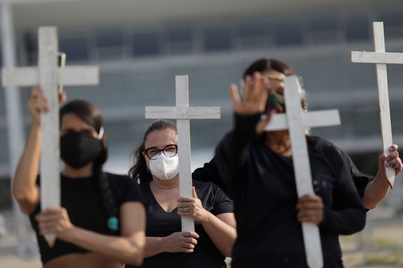 &copy; Reuters. Demonstrators hold crosses during a protest to pay tribute to Brazil's 600,000 COVID-19 deaths and against Brazil's President Jair Bolsonaro's handling of the coronavirus disease pandemic, in Brasilia, Brazil, October 8, 2021. REUTERS/Ueslei Marcelino