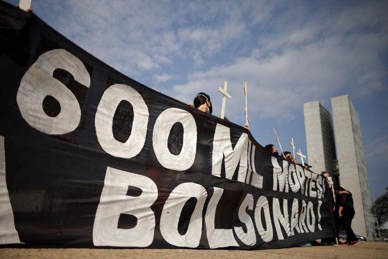 &copy; Reuters. Personas se manifiestan contra el presidente Jai Bolsonaro debido a que Brasil sueró las 600.000 muertes como consecuencia del COVID-19, en Brasilia, Brasil. Octubre 8, 2021. REUTERS/Ueslei Marcelino