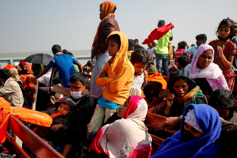 © Reuters. صورة من أرشيف رويترز للاجئين من الروهينجا يجلسون على مقاعد خشبية لسفينة تابعة للبحرية في طريقهم لجزيرة باشان شار ببنجلادش.