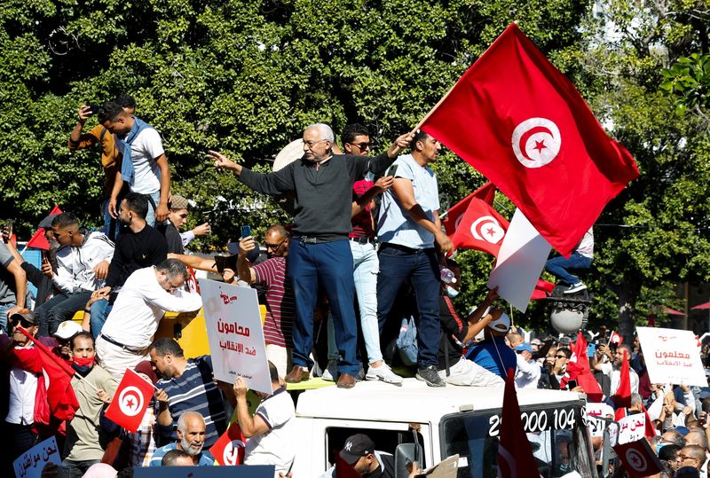 &copy; Reuters. متظاهرون يرفعون أعلاما ولافتات خلال احتجاج في تونس العاصمة يوم الأحد على سيطرة الرئيس قيس سعيد على مقاليد السلطة في البلاد. تصوير: زبير السو