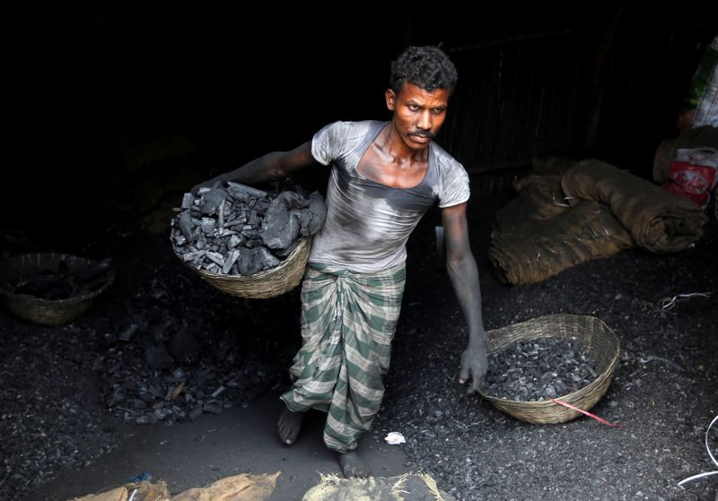 &copy; Reuters. 　インドの北部州では、石炭不足のためにたびたび停電が起こり、電力危機が深刻化していることが政府データの分析と住民への取材で分かった。写真は石炭を運ぶ労働者。５月ムンバイで