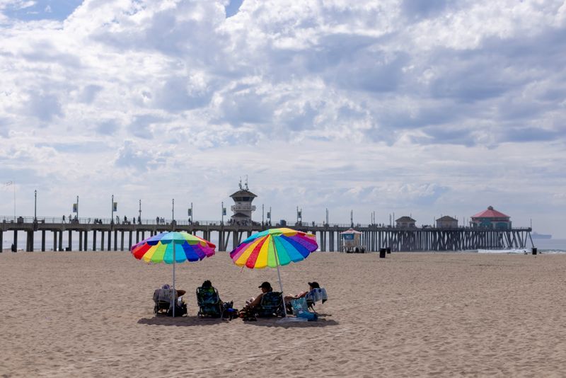 &copy; Reuters. FILE PHOTO: Beachgoers relax in the sand a long way from the water when authorities closed access after a major oil spill off the coast of California came ashore in Huntington Beach, California, U.S. October 4, 2021. REUTERS/Mike Blake