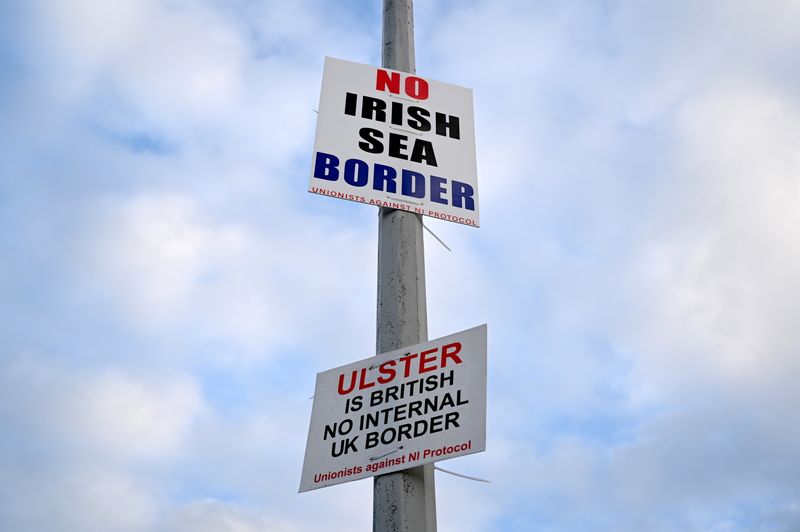 &copy; Reuters. FILE PHOTO: Signs reading 'No Irish Sea border' and 'Ulster is British, no internal UK Border' are seen affixed to a lamp post at the Port of Larne, Northern Ireland, March 6, 2021.  REUTERS/Clodagh Kilcoyne/File Photo