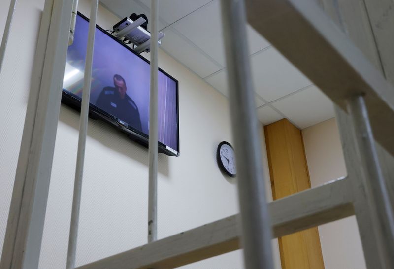 &copy; Reuters. FILE PHOTO: Russian opposition leader Alexei Navalny is seen on a screen via a video link during a hearing to consider his lawsuits against the penal colony over detention conditions there, at the Petushki district court in Petushki, Russia May 26, 2021. 
