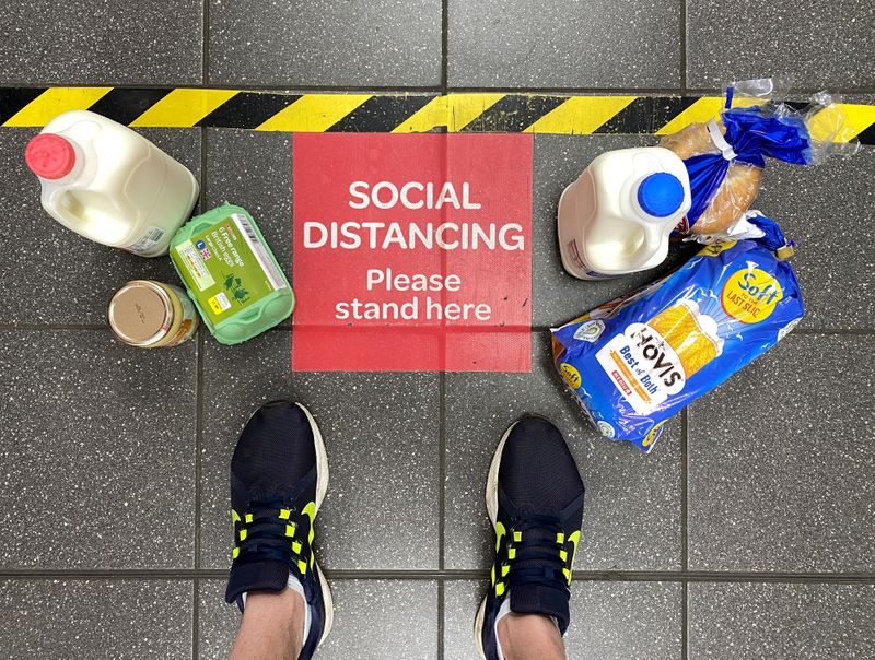 &copy; Reuters. FILE PHOTO: Food shopping is seen on the floor next to a social distancing sign and markings as a customer waits in a queue at a Spar supermarket, following the outbreak of the coronavirus disease (COVID-19) in Hemel Hempstead, Britain, April 24, 2020. RE