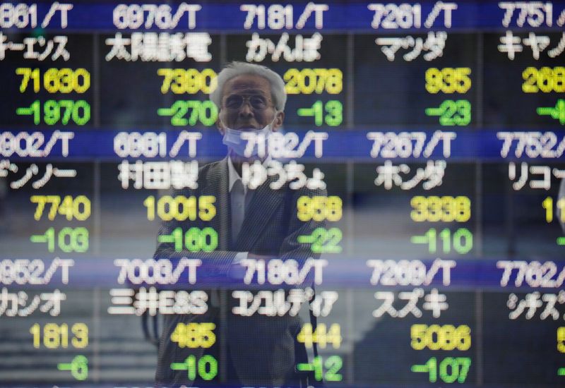 &copy; Reuters. FILE PHOTO: A man wearing a protective mask, amid the COVID-19 outbreak, is reflected on an electronic board displaying stock prices outside a brokerage in Tokyo, Japan, September 21, 2021. REUTERS/Kim Kyung-Hoon