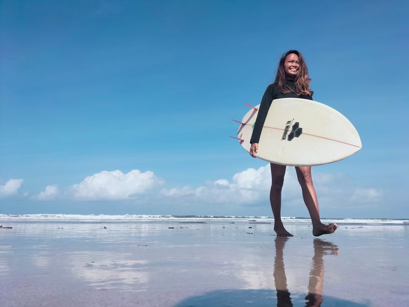 &copy; Reuters. Foto de Halfia Lando, dueña de una escuela de surf, posando con una tabla en la playa de Kuta 
Oct 12, 2021. REUTERS/Sultan Anshori
PROHIBIDA SU REVENTA O SU USO COMO ARCHIVO