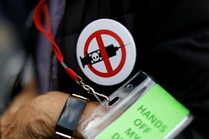 &copy; Reuters. FILE PHOTO: A man wears an anti-vaccine button as people and teachers protest against New York City mandated vaccines against the coronavirus disease (COVID-19) in front of the United States Court in Manhattan in New York City, New York, U.S., October 12,