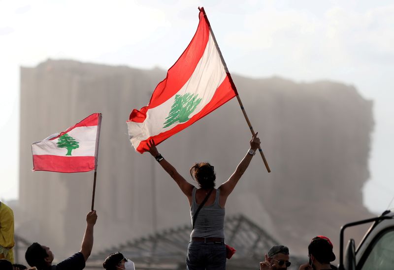 &copy; Reuters. FILE PHOTO: Demonstrators wave Lebanese flags during protests near the site of a blast at Beirut's port area, Lebanon August 11, 2020. REUTERS/Goran Tomasevic/File Photo