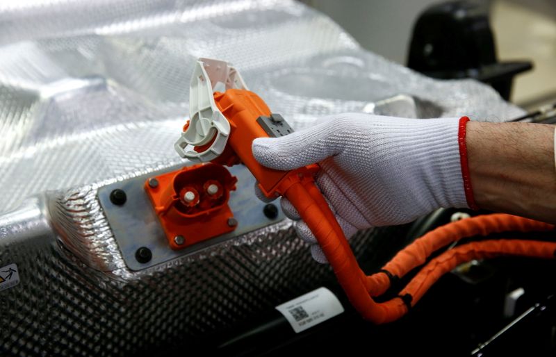 © Reuters. FILE PHOTO: A worker connects the battery during the assembly of an e-Golf electric car at the new production line of the Transparent Factory of German carmaker Volkswagen in Dresden, Germany March 30, 2017. REUTERS/Fabrizio Bensch