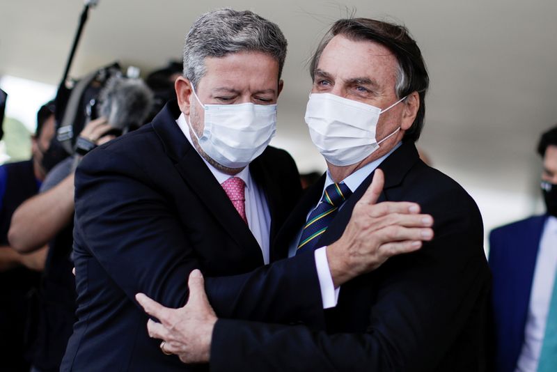 &copy; Reuters. Presidente da Câmara dos Deputados, Arthur Lira, abraça presidente Jair Bolsonaro em Brasília
25/03/2021 REUTERS/Ueslei Marcelino