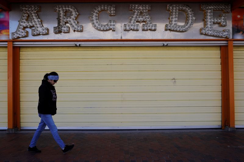 &copy; Reuters. FILE PHOTO: A woman walks past the arcade closed amid the coronavirus disease (COVID-19) outbreak in Old Orchard Beach, Maine, U.S., April 25, 2020. REUTERS/Brian Snyder