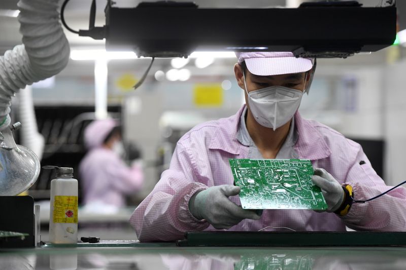 &copy; Reuters. FOTO DE ARCHIVO: Una empleada inspecciona un circuito impreso en una cadena de producción en Wuhan, provincia de Hubei, China, el 16 de agosto de 2021. China Daily vía REUTERS